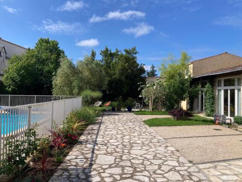 a stone walkway in front of a house at La Villa des Roses Gîte Chambres d'hôtes Piscine chauffée in Luçon