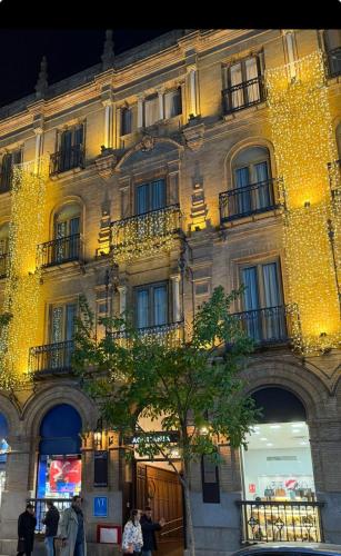 a building with christmas lights on the side of it at Aquitania Home Suites in Seville