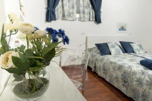 a living room with a table with a vase of flowers at Il Podestà in Fabriano