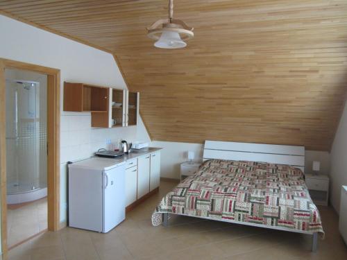 een slaapkamer met een bed en een kleine keuken bij Apartments Centrum in Liptovský Mikuláš