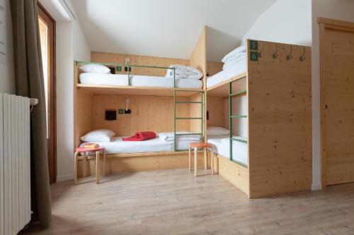 Uma cama ou camas num quarto em Ostello Alpino