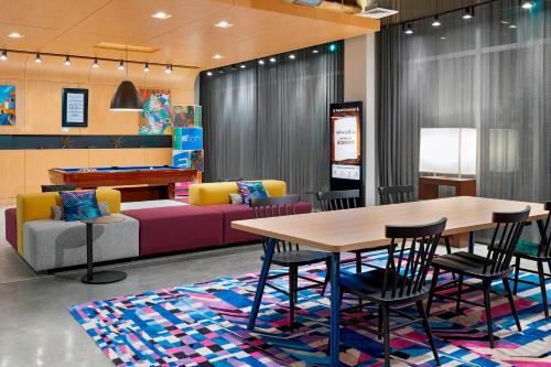 a room with a table and chairs and a couch at Aloft Jacksonville Airport in Jacksonville