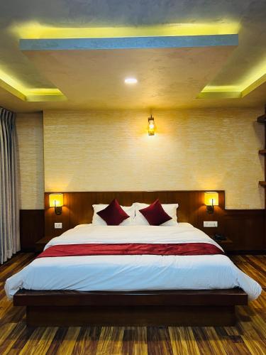 a bedroom with a large bed with red pillows at Hotel Nova Nook Pvt Ltd in Kathmandu