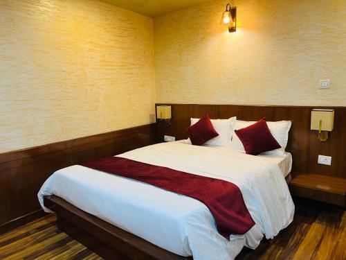 a bedroom with a large bed with red pillows at Hotel Nova Nook Pvt Ltd in Kathmandu
