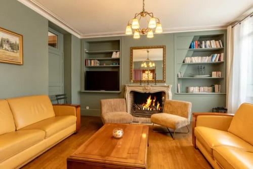 un salon avec un canapé et une cheminée dans l'établissement Villa Jane'Laur Magnificent mansion with garden 11 P, à Honfleur