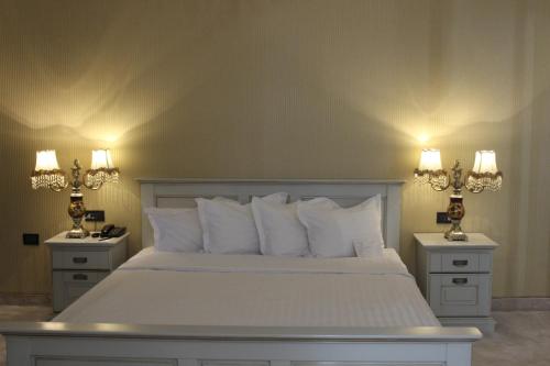 a bedroom with a white bed with two night stands at Phoenicia Grand Hotel in Bucharest