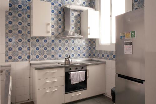 een keuken met witte kasten en blauwe en witte tegels bij My Address in Barcelona in Barcelona