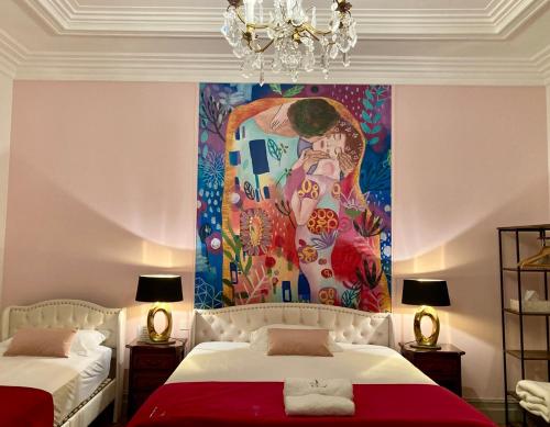 a room with two beds and a painting on the wall at La Villa des Roses Gîte Chambres d'hôtes Piscine chauffée in Luçon