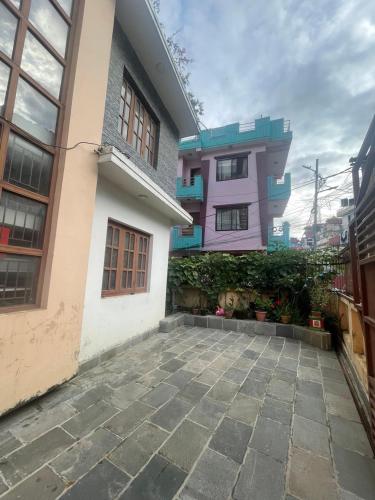 Casa con patio de piedra frente a un edificio en Blissful Himalayas Home, en Bālāju