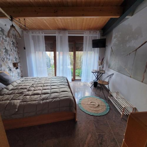 a bedroom with a large bed and a large window at Maison de charme 175m2 - 5 chambres in Aignay-le-Duc