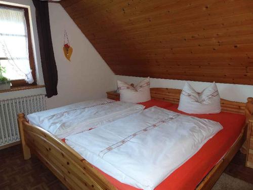 a bedroom with a bed with white sheets and pillows at Schlossberghof in Haslach im Kinzigtal