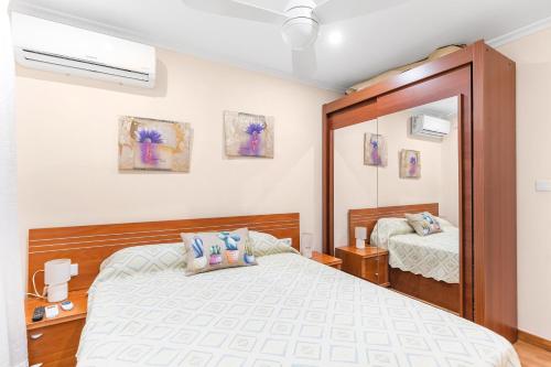 a bedroom with a bed and a mirror at Yovalu1 Apartamento En Torrevieja C in Torrevieja