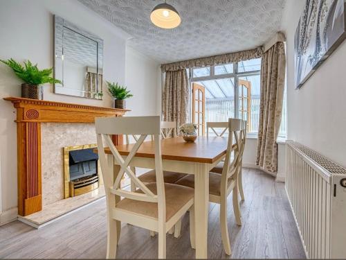 a dining room with a table and a fireplace at Petsol Apartments in Birmingham
