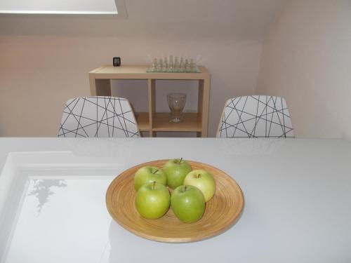 a bowl of apples on a plate on a table at Apartment Seven Ducks in Aalen