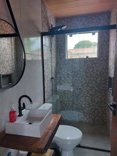 a bathroom with a toilet and a sink and a shower at Casa da Paz -Praia do Rosa in Imbituba