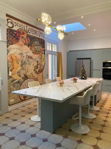 a kitchen with a large table with chairs and a mural at La Villa des Roses Gîte Chambres d'hôtes Piscine chauffée in Luçon