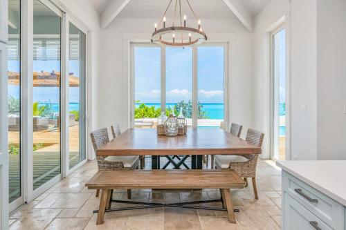 a dining room with a table and views of the ocean at Luxury Beachfront Villa On The Sand With Pool in Hartswell