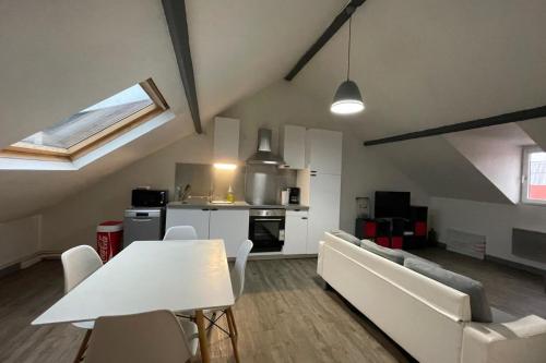 un salon avec une table blanche et un canapé dans l'établissement La Mansardé Baheux, au Havre