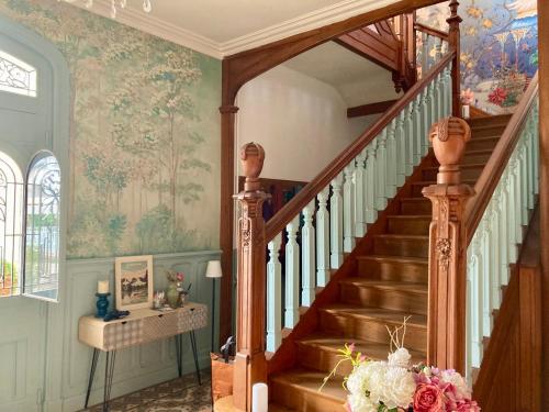 a staircase in a home with a painting on the wall at La Villa des Roses Gîte Chambres d'hôtes Piscine chauffée in Luçon