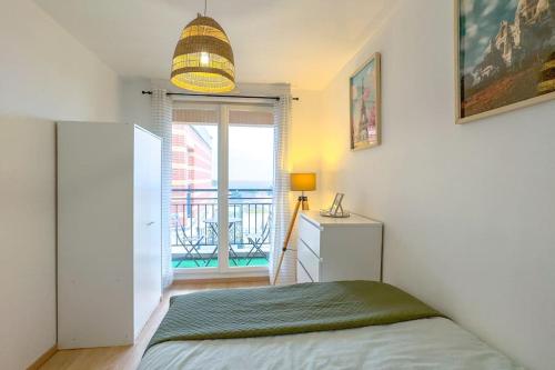 une chambre avec un lit et une grande fenêtre dans l'établissement Appartement lumineux et cosy 2 pièces, à Athis-Mons