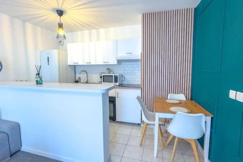- une cuisine avec une table, une table et des chaises dans l'établissement Appartement lumineux et cosy 2 pièces, à Athis-Mons