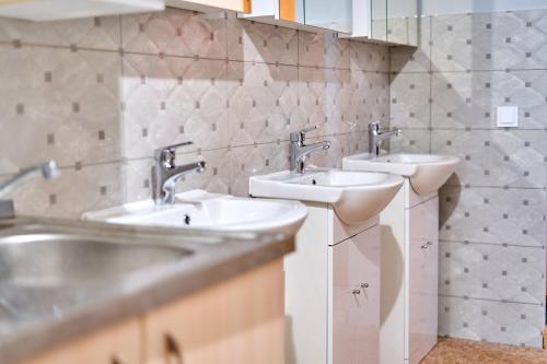 a bathroom with two sinks and two mirrors at Tokyo Vibes - Private Sleeping Pods Hostel, Self check-in in Vilnius