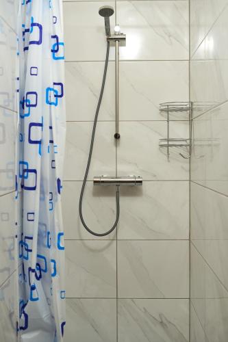 a shower with a shower head in a bathroom at Tokyo Vibes - Private Sleeping Pods Hostel, Self check-in in Vilnius