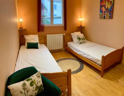 a room with two beds and a couch and a window at La Villa des Roses Gîte Chambres d'hôtes Piscine chauffée in Luçon