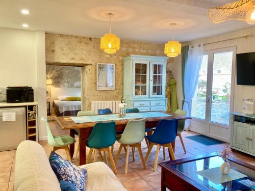 a kitchen and living room with a table and chairs at La Villa des Roses Gîte Chambres d'hôtes Piscine chauffée in Luçon
