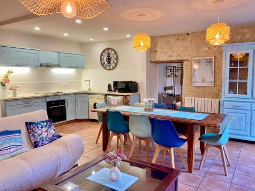 a kitchen and living room with a table and chairs at La Villa des Roses Gîte Chambres d'hôtes Piscine chauffée in Luçon