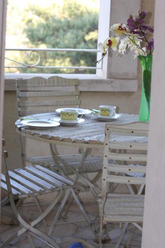 a table with two plates and a vase of flowers at Pousterle de Sabran - Piscine & Hammam in Sabran
