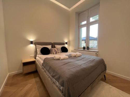 a bedroom with a large bed and a window at Goldhammer Premium Apartments in Tarnów