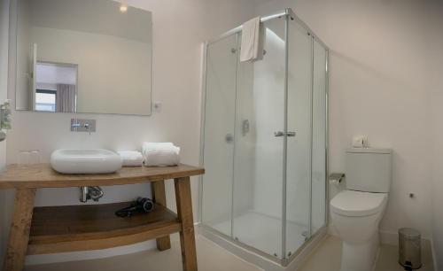a bathroom with a glass shower and a toilet at Sunrise House 26 in Ponta Delgada