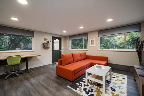 a living room with an orange couch and a desk at #StayInMyDistrict Multnomah Village Modern Retreat in Portland