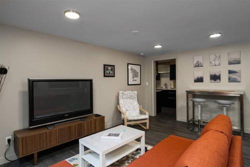 a living room with a couch and a flat screen tv at #StayInMyDistrict Multnomah Village Modern Retreat in Portland