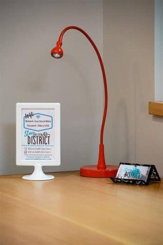 a lamp sitting next to a computer on a wooden floor at #StayInMyDistrict Multnomah Village Modern Retreat in Portland