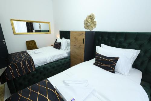 a hotel room with two beds and a mirror at Golden Hill Palace in Novi Pazar