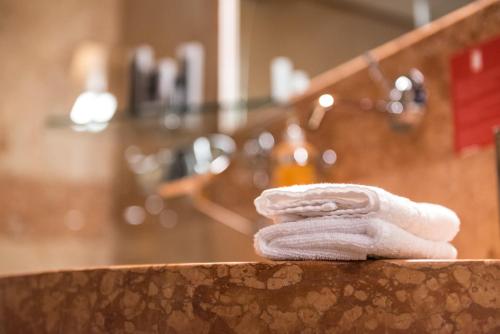 a white towel sitting on a counter in a bathroom at Hotel Veronesi La Torre in Dossobuono