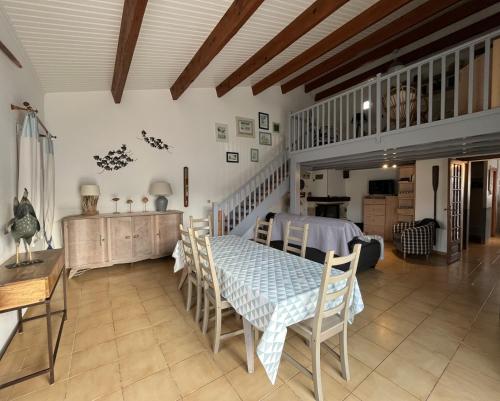 une salle à manger avec une table et des chaises dans l'établissement Maison La Rabouillère avec jardin arboré, au Bois-Plage-en-Ré