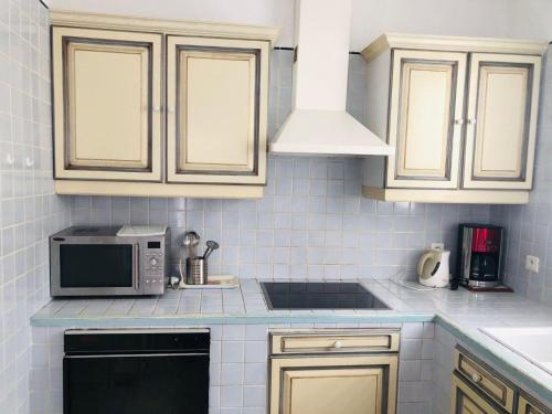 une cuisine avec des armoires blanches et un micro-ondes dans l'établissement Casa Aregno - Charme et Sérénité, à Aregno