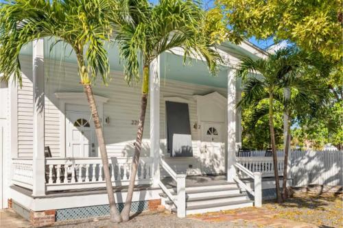 a white house with palm trees in front of it at Mesa House, Uno-Perfect Location in Key West