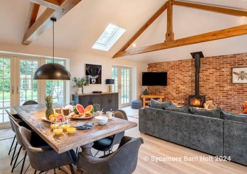 un soggiorno con un tavolo e un divano di Sycamore Barn a Holt