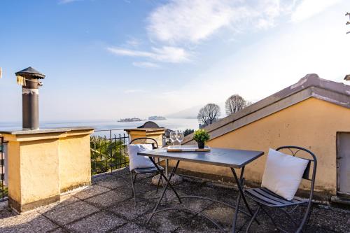 a patio with a table and chairs on a balcony at Elm Alley Apartment - Baveno - Free Wi-Fi in Baveno