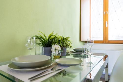 a dining room table with plates and wine glasses at Elm Alley Apartment - Baveno - Free Wi-Fi in Baveno