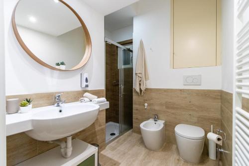 a bathroom with a sink and a toilet and a mirror at Elm Alley Apartment - Baveno - Free Wi-Fi in Baveno
