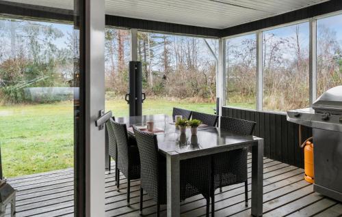 a screened in porch with a table and chairs at 1 Bedroom Amazing Home In Gedser in Gedser