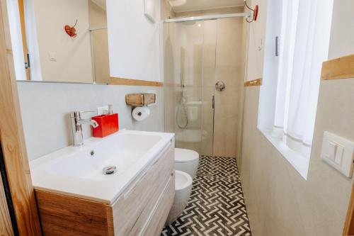 a bathroom with a white sink and a toilet at Luxury Chalet Liosa - Ski in Ski out - Amazing view in Corvara in Badia