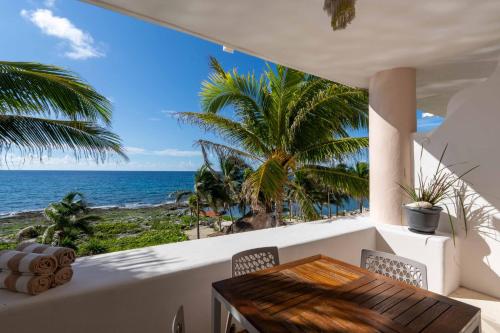 a balcony with a table and chairs and the ocean at 2 BR Apartment sea view in Puerto Aventuras