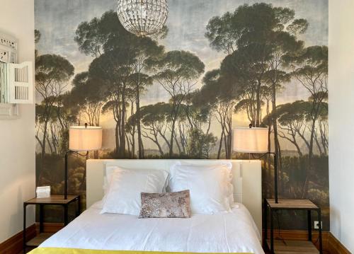 a bedroom with a large mural of trees on the wall at La Villa des Roses Gîte Chambres d'hôtes Piscine chauffée in Luçon