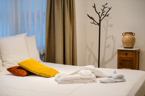 a white bed with towels and a vase on a table at Circa 1929 in Ostend